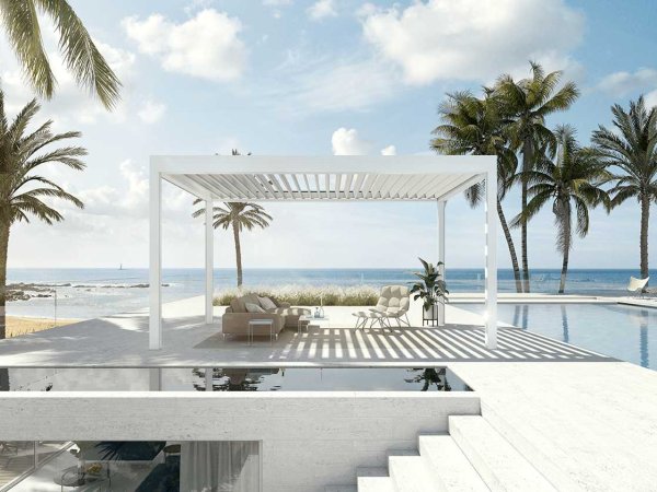 Das freistehende Lamellendach Lamaxa von Warema in weiß direkt am Pool mit Blick auf das Meer.