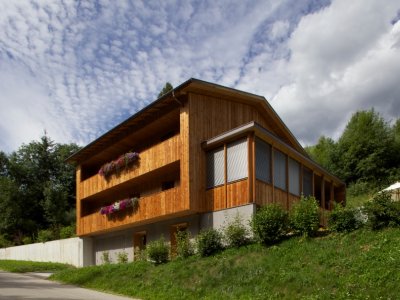 Ein Holzhaus im Grünen mit Raffstoren als Blendschutz, Sonnenschutz, Klimargulierung.