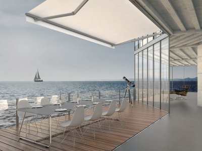 Hella Offene Gelenkarmmarkise auf einer Terrasse mit Blick auf das Meer