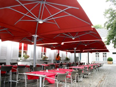 Zangenberg Multipole mit Beleuchtung als Sonnenschutz für ein Café.