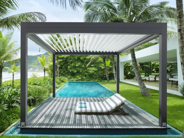 Das bewegliche Lamellendach Varia von Gibus in einem sonnigen Garten mit Pool direkt an einer Terrasse.