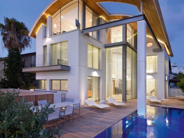 Architekten Haus mit Raffstoren und einer Terrasse mit Pool.