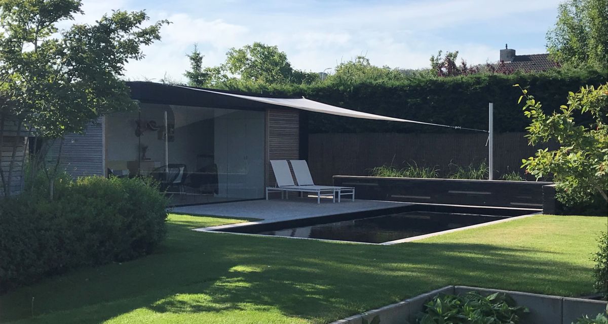 Das verstellbare Sonnensegel Ingenua von Umbrosa in einem wunderschönen Garten mit Swimmingpool, bei Frimey GmbH.