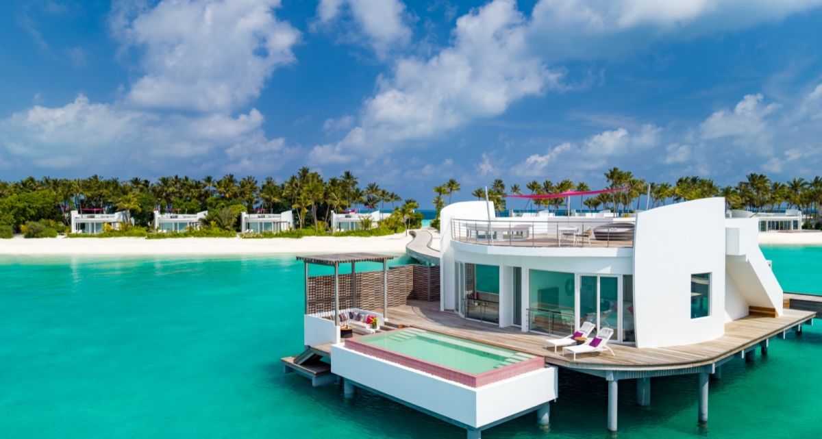 Das Sonnensegel Ingenua von Umbrosa als Schattensegel auf einem Appartmenthaus eines Hotels mitten im Meer, bei Frimey GmbH.