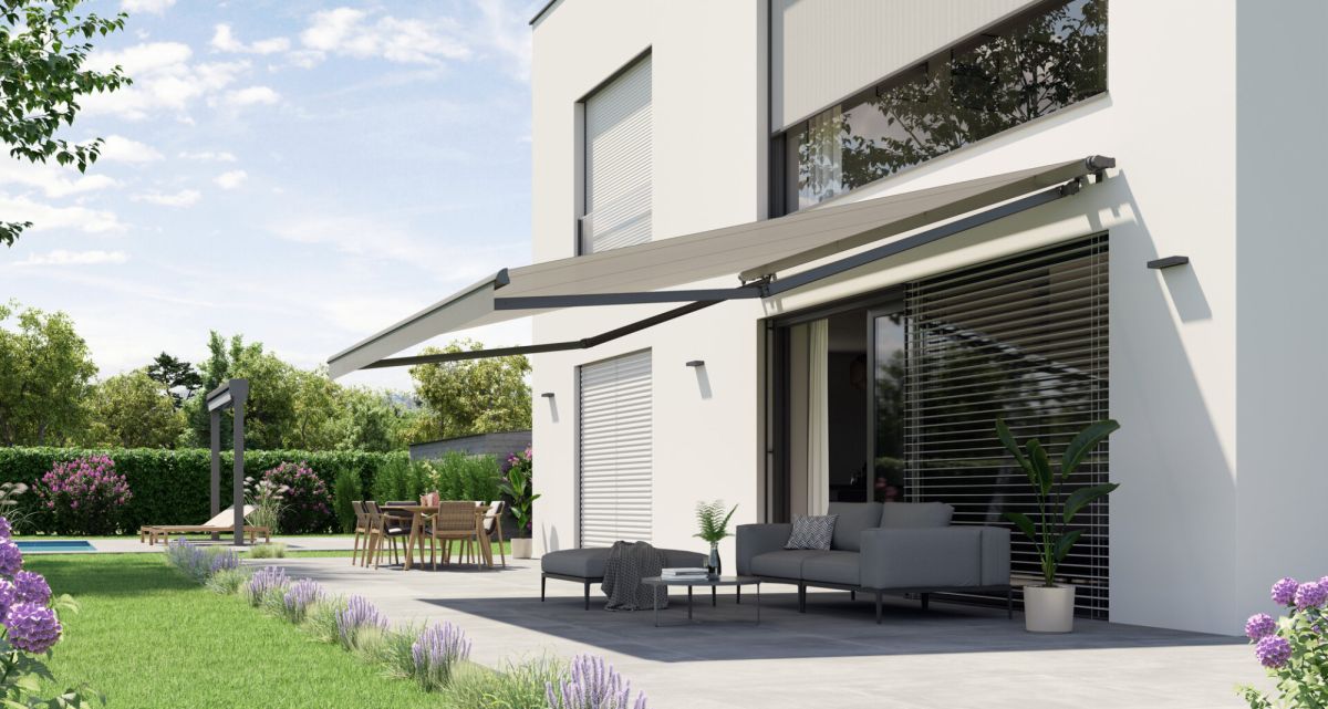 Die stabile Gelenkarmmarkise Trendline von WOundWO an einem wunderschönem Haus mit Garten, bei Frimey GmbH.