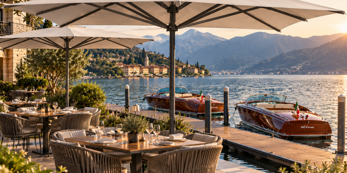 Der hochwertige Sonnenschirm Verona von Scolaro mit stabilen Mittelmast als Sonnenschutz auf einer Terrasse eines Restaurants direkt am See mit Riva Boote, bei Frimey GmbH.