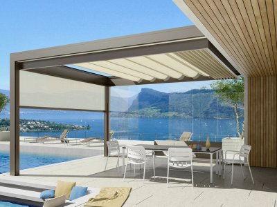Die Klaiber Bavona Pergola seitlich am Haus als Wandmontage, mit intergierten ZIP Senkrechtmarkisen und Glasschiebetüren.