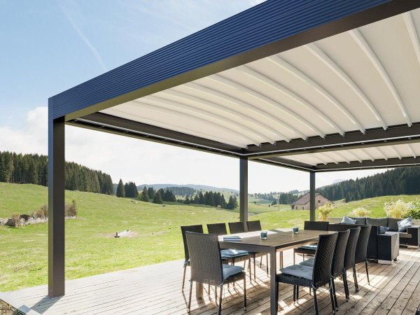 Die regendichte Pergola Gibus Azimut auf einer Terrasse mit Blick in die sommerlich grüne Landschaft.