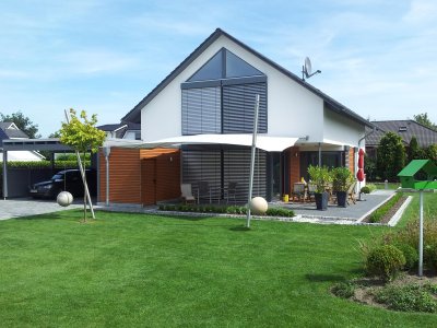 Das hochwertige Sonnensegel Square Cross von C4Sun an einen Einfamilienhaus mit Sonnenschutz Raffstores.
